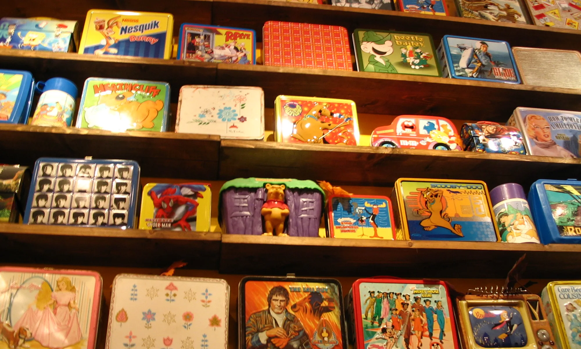 Vintage metal lunch boxes lined up on a shelf